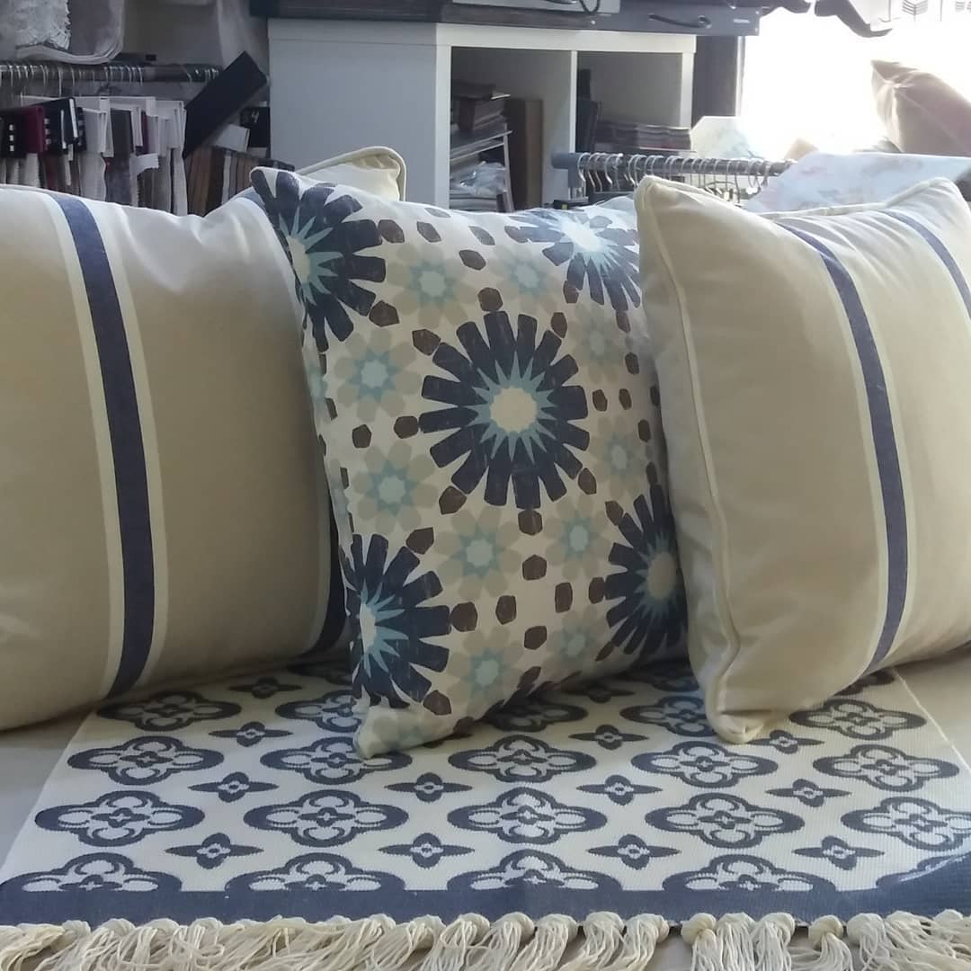 Cojines decorativos con estampados geométricos y bordes en tonos azules en Marbella.